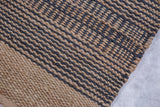 Textured Coby jute rug features a tight geometric weave of natural and dark gray diagonal stripes.