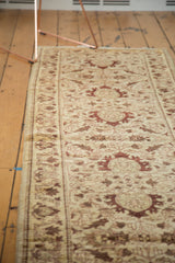 Angled view of an Egyptian runner showing its Sultanabad design in wine red on an antique ivory field.