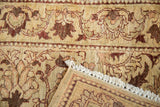 Folded corner of an Egyptian rug showing its hand-knotted back, ivory fringe, and vinery pattern.