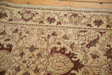 Close-up of the hand-knotted pile showing intricate vinery and serrated leaf motifs.