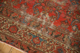 Distressed antique Malayer rug detail: worn cranberry field, sky blue motifs, beige border, and white fringe.