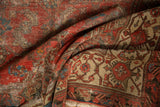 Detail of a folded antique Malayer rug: distressed pile, visible foundation, and intricate Herati motif.