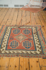 Antique Kazak rug featuring bold madder red geometric motifs and characteristic storied wear.
