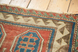 Antique Kazak rug's geometric reciprocating border, displaying madder red, sky blue, and etched brown tones.