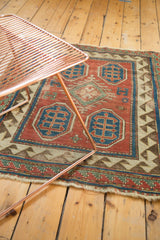Well-worn antique Kazak rug section, highlighting bold blue motifs and a reciprocating border.