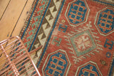 Antique Kazak rug, reciprocating border and geometric patterns in madder red and blue.