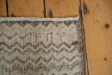 Weaver initials and distressed chevron pattern at the corner of a vintage Tulu rug.