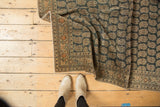 Antique Tabriz rug corner with intricate botehs on a charcoal oxidized silver field.