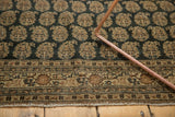 Antique Tabriz rug detail: border, layered boteh pattern on unusual charcoal, visible wear.