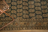 Antique Tabriz rug with intricate boteh motifs on charcoal field and multi-banded border.