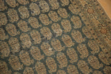 Antique Tabriz field of tan botehs on charcoal, with visible border and mostly even wear.