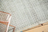 Distressed Oushak rug detail showing checker motif, ivory, sea foam green, oxidized silver.
