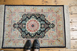 Vintage Hereke silk rug showing finely woven ivory, navy, and blush floral field details.