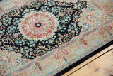 Vintage Hereke rug's fine silk weave with navy field and intricate blush, red, and blue floral border.