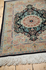 Finely woven border with blush, gold, and light blue floral patterns and ivory fringe.
