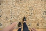Vintage distressed Tabriz rug with ivory, brown, and navy teal geometric patterns, foundation visible.