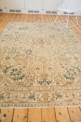 Distressed vintage Tabriz carpet, showing fringed end with pale blue and brown border.