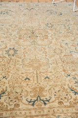 Vintage distressed Tabriz rug with ivory, coffee brown, and teal serrated rectilinear patterns.