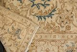 Folded vintage Tabriz rug showing distressed pile, geometric design, ivory, brown, and navy teal.