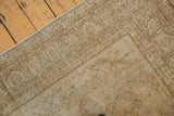 Distressed corner of a vintage Amritsar rug, showcasing low pile and muted floral patterns.