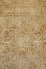 Distressed vintage Amritsar carpet showcasing low pile, faded gold, beige Herati motif, and wear.