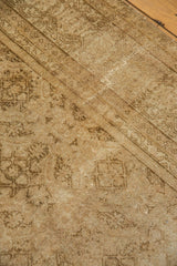 Distressed vintage Amritsar rug, low pile, sand-gold tones, subtle Herati, visible split.