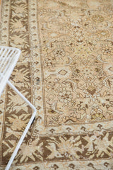Oversized floral border and Herati field of a distressed vintage Malayer carpet in bronze and sand tones.