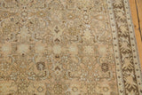 Distressed texture of a vintage Malayer rug with visible knot heads and Herati motifs in sand and bronze.