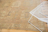 Distressed Oushak rug with faded geometric border and low pile in sand and gray.