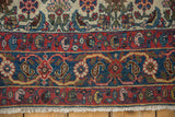 Halvai Bijar rug border featuring madder red, sky blue, floral motifs and ivory fringe.