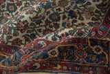 Folded vintage Halvai Bijar rug showing intricate Herati motif on ivory with a madder red border.