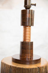 Solid dark oak body of an Edison lamp with a central hand-twisted copper coil.