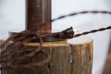 Vintage-style plug and brown fabric-wrapped cord at the base of the oak lamp.