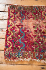 Tattered red end border of antique Yastik rug with abstract germinating plant motifs.