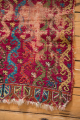 End border of antique Yastik rug with germinating plant motifs and tattered fringe.