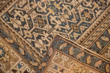 Antique Caucasian rug fold revealing navy, sand animated geometric pattern and hand-knotted reverse.