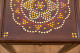 Painted vintage end table top detail with cream, maroon, and gold dot pattern.