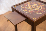Vintage end table's dark wood pull-out tray extended, showing its small brass knob.