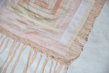 Lea Thomas quilt weaving corner showing soft pink hand-dyed fabric and delicate fringe.