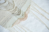 Varied textures and soft blush tones from hand-dyed yarns in a Lea Thomas textile.