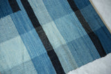 Textured close-up of Lea Thomas weaving with hand-dyed blues in geometric block patterns.