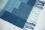 Lea Thomas hand-dyed fringes in pale and deep blues on textured woven art.