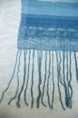 Hand-dyed blue fringe and detailed, open weave texture of the Lea Thomas weaving.