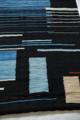 Interwoven patterns of blue, beige, and fine red threads on a dark ground.