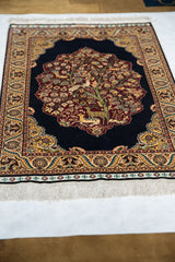 An angled view captures the intricate Tree of Life with birds and deer on a fine Hereke rug.