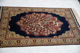 Perspective view of a fine pictorial Hereke rug with its lustrous silk pile and intricate borders.