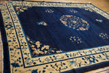 Hand-knotted vintage Peking carpet's deep indigo field with beige and sky blue floral bouquet.