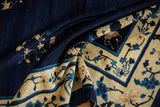 Fluid blue and beige borders with scrolling floral vinery on a vintage Peking carpet.