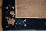 Navy blue border with blossomed ornamentation, beige field, intact selvage of vintage Peking rug.
