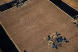 Vintage Peking rug detail: beige field texture with blue and ivory floral bouquet.
